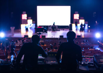 Blur image of sound engineer team working to prepare for music concert stage.