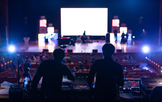 Blur image of sound engineer team working to prepare for music concert stage.