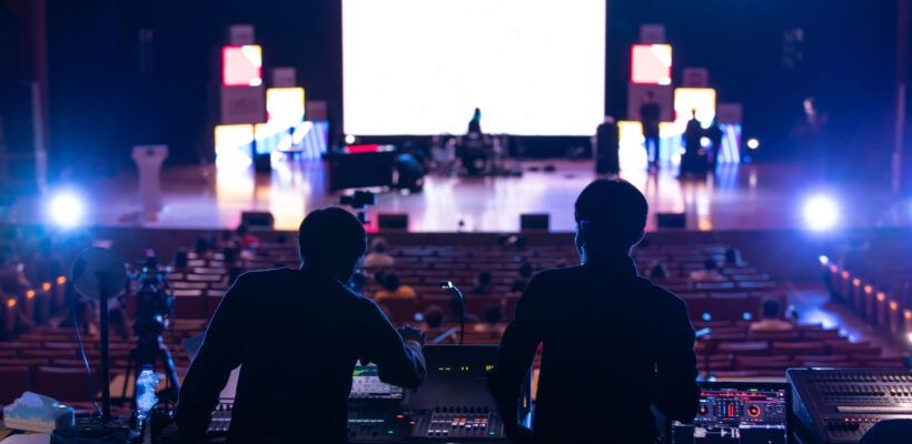 Blur image of sound engineer team working to prepare for music concert stage.