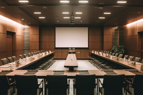 A professional and well-equipped conference seminar room featuring a microphone as its focal point. The image should portray a sleek and modern setting, conveying a sense of professionalism and sophistication. The conference seminar room should have a spacious layout with comfortable seating arrangements, allowing participants to engage in discussions and presentations. The decor can feature neutral tones, emphasizing a clean and professional atmosphere. The room should be well-lit, with ample natural or artificial light to create an inviting ambiance. The microphone should be positioned prominently at the front of the room, on a sleek stand or podium. It should be a high-quality, professional-grade microphone, symbolizing the importance of clear and effective communication in a seminar or conference setting. The microphone can be designed with modern aesthetics, reflecting the advancements in technology and audio equipment. The room can be filled with attendees, either seated or standing, engaged in active participation. Their presence should convey a sense of excitement and intellectual exchange, enhancing the overall atmosphere of the conference seminar room. The lighting effect should be bright and evenly distributed, ensuring clear visibility for all participants. It can be achieved through overhead lighting fixtures or natural light streaming through large windows. The lighting should complement the room's design and create an energizing and focused environment. Overall, the image should convey a sense of professionalism, knowledge sharing, and engagement. It should capture the essence of a conference seminar room, where ideas are exchanged, connections are made, and impactful discussions take place.